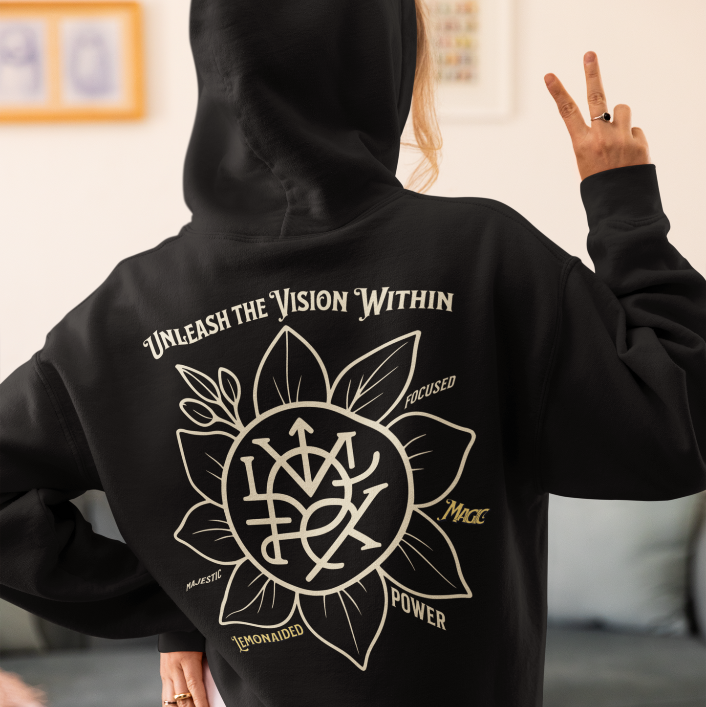 Person wearing a black hoodie with a white design and text on the back, standing in a room. Lifestyle photo of Lemonaided Magic hoodie with hand-drawn personalized sigil — Mercury Loves Osiris